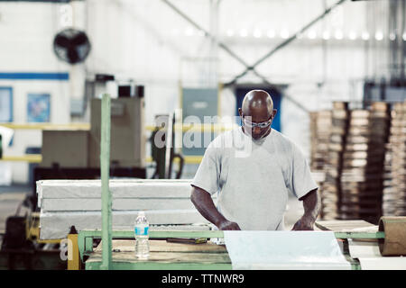 Lavoratori anziani lavorando sulla macchina presso l'industria Foto Stock