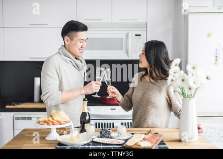 Coppia felice Prosecco di tostatura in cucina a casa Foto Stock