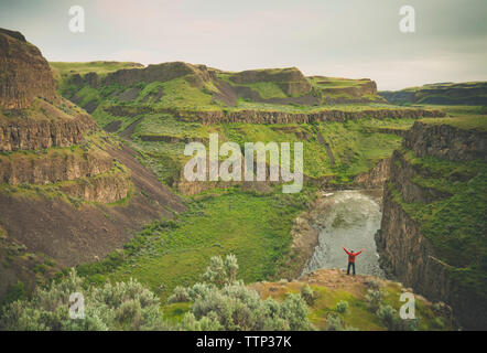 Vista posteriore dell'uomo con le braccia aperte a riposo a Palouse Falls State Park Foto Stock