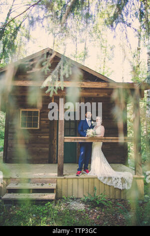 Ritratto di sposa giovane in piedi nel portico a forest Foto Stock