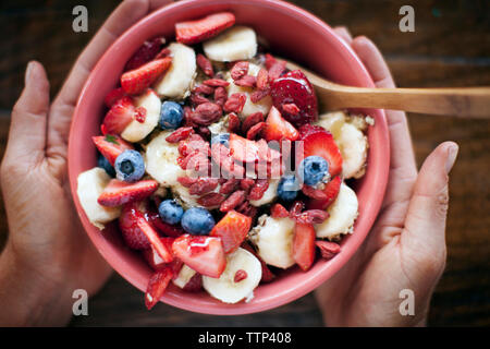 Immagine ritagliata di mani ciotola di cereali per la prima colazione Foto Stock