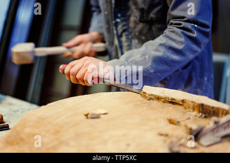 Sezione mediana del falegname maschio del cesello di legno in officina Foto Stock