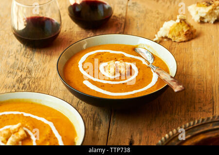 Close-up di zucca zuppa nel vaso sul tagliere a tavola Foto Stock