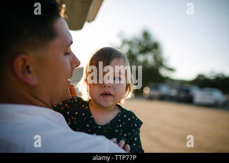 Vista posteriore del padre che porta la figlia Foto Stock