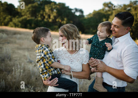 La famiglia felice in piedi sul campo Foto Stock