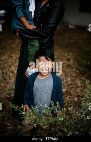 Bambino piangere mentre madre figlio che porta sul campo erboso a Balboa Park Foto Stock