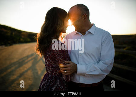 Il marito e la moglie abbracciare e sorridente con la Sunflare in SoCal Foto Stock