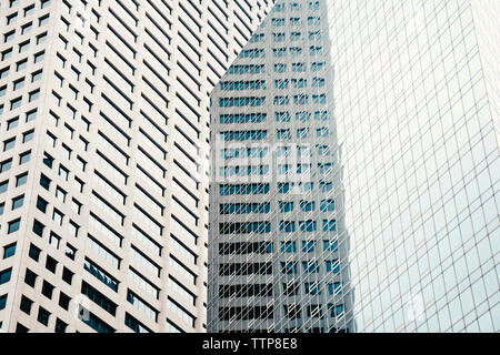 Basso angolo vista di edificio moderno che riflette su windows Foto Stock