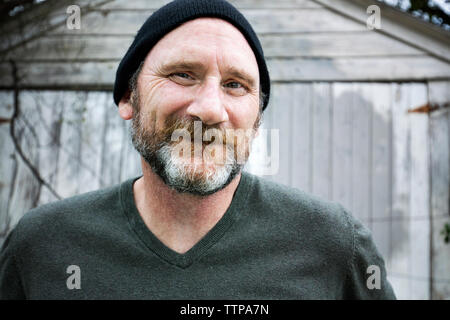 Close-up ritratto di uomo sorridente indossando knit hat Foto Stock