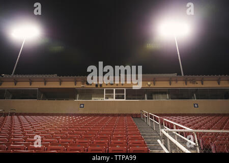 Basso angolo di vista sedi vuote a illuminato american football Stadium Foto Stock