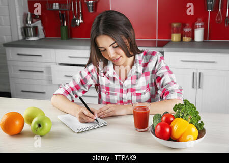 Cibo sano concetto. Giovane donna seduta al tavolo con frutta e verdura Foto Stock