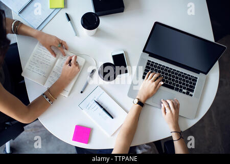 Vista aerea di imprenditrici lavorando a tavola in ufficio creativo Foto Stock