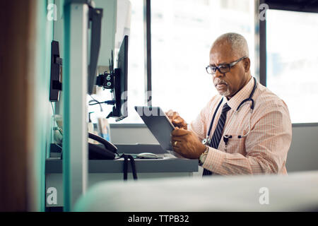 Medico utilizzando computer tablet in ospedale Foto Stock