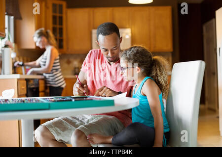 Padre colorazione con la figlia a tavola Foto Stock