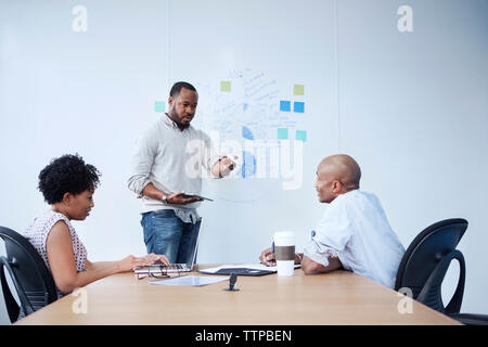 uomo d'affari che spiega i colleghi in sala riunioni Foto Stock