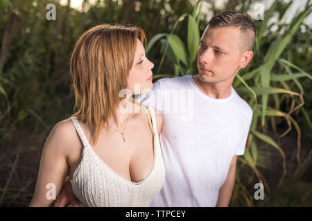 Amare l uomo e la donna felice in una molla parco fiorito. Felice Coppia matura in amore abbracciando outdoor Foto Stock