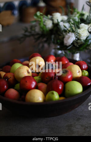 Angolo di alta vista di frutta nel recipiente dal vaso di fiori sul tavolo Foto Stock