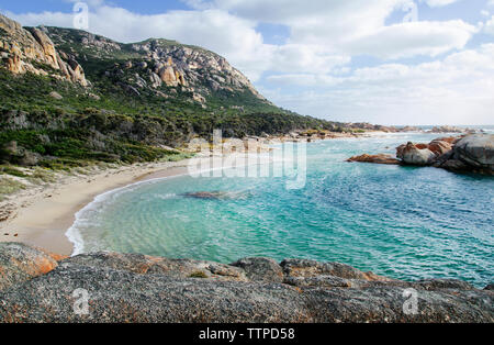 Idillica vista mare e montagna contro il cielo nuvoloso Foto Stock