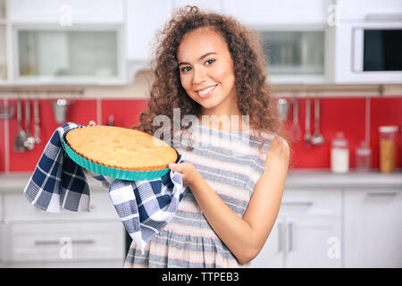 Bella ragazza africana con torta in cucina Foto Stock