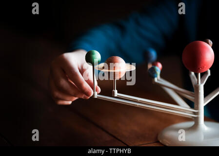 Una piccola mano ragazzi toccando un modello del Sistema Solare Foto Stock