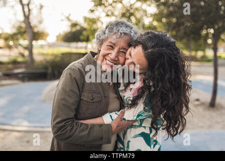 Felice figlia abbracciando madre senior presso il park Foto Stock
