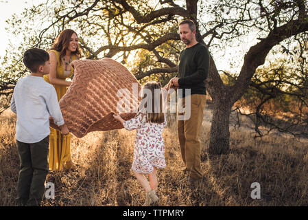 Madre guardando la figlia mentre la famiglia svolge nel campo della California Foto Stock