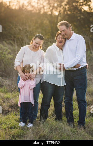 Famiglia multigenerazionale abbracciando in campo Foto Stock