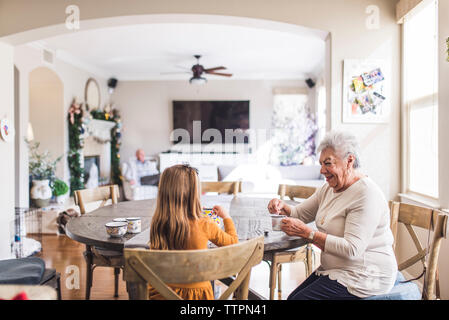 Famiglia multigenerazionale giocando con il set per il tè al tavolo della cucina Foto Stock