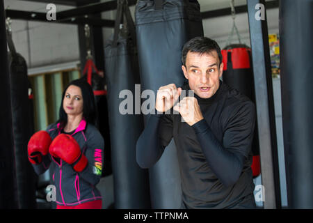 Coach training boxer femmina in palestra Foto Stock