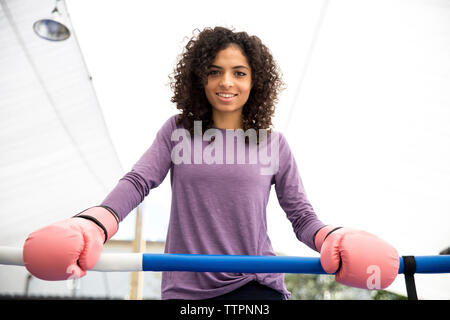 Ritratto di donna sorridente boxer in piedi di pugilato ring Foto Stock