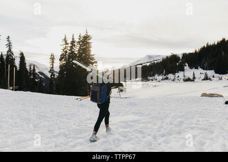 Giovane donna con zainetto sci sulla spalla durante il periodo invernale Foto Stock