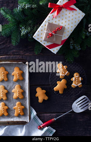 Vista dall'alto dell'uomo del pan di zenzero con regali di natale e utensili sul tavolo Foto Stock