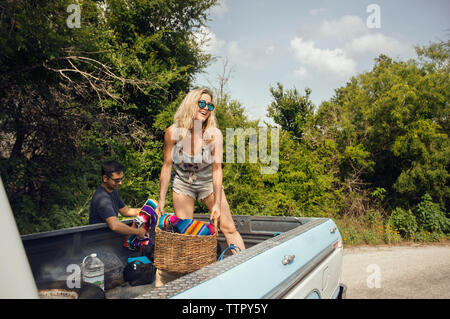 Donna cestello di scarico mentre si sta in piedi sul pick-up Foto Stock