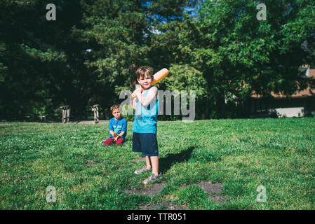 Fratelli a giocare a baseball in posizione di parcheggio Foto Stock