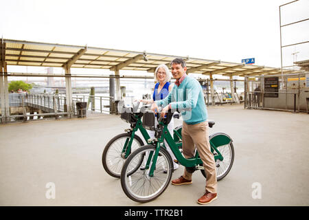 Ritratto di felice coppia matura in piedi con le biciclette sul sentiero Foto Stock
