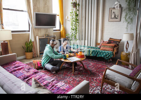 L' Omosessuale maschi quotidiano di lettura pur avendo prima colazione a casa Foto Stock