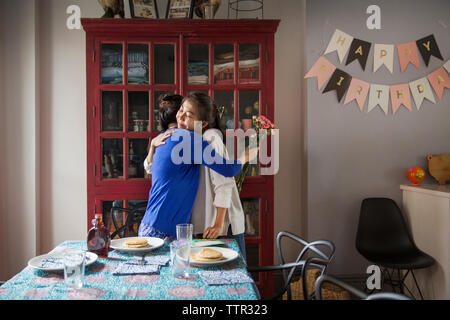 Madre e figlia abbracciando durante la celebrazione di compleanno Foto Stock