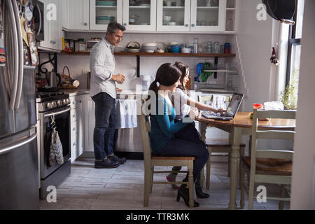 La famiglia felice in cucina a casa Foto Stock