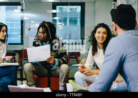 I colleghi a discutere mentre è seduto in ufficio creativo Foto Stock