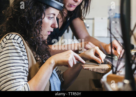 Sezione mediana del maestro che insegna agli studenti di forma ad anello sulla tavola in officina Foto Stock