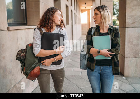 Due giovani studenti camminare insieme nel collegio Foto Stock