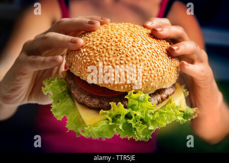 Donna che mantiene freschi hamburger, primo piano Foto Stock