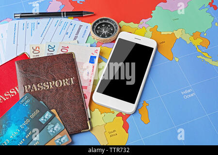 Carte di credito e biglietti sulla mappa del mondo sullo sfondo Foto Stock