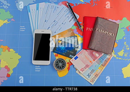 Carte di credito e biglietti sulla mappa del mondo sullo sfondo Foto Stock