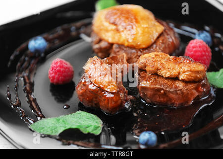Succosa carne con salsa dolce sulla piastra nera Foto Stock