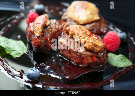 Succosa carne con salsa dolce sulla piastra nera Foto Stock