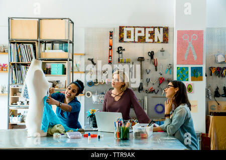 Fashion designer che lavorano su manichino in ufficio creativo Foto Stock