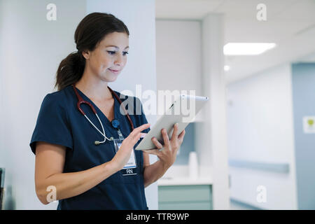 Fiducioso medico donna utilizzando computer tablet in ospedale Foto Stock