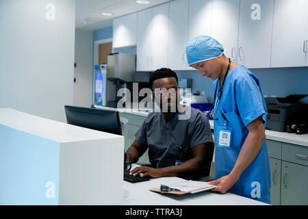 Medico e chirurgo revisione medica sul grafico negli appunti al ricevimento dell'ospedale Foto Stock