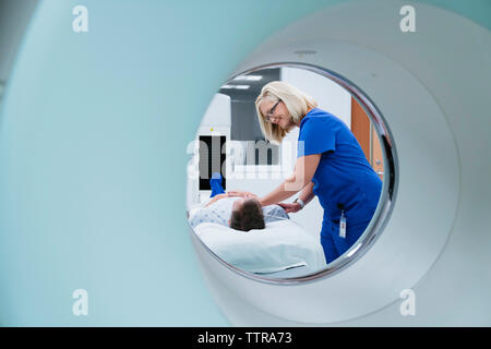 Infermiere preparazione paziente per MRI scan in ospedale Foto Stock